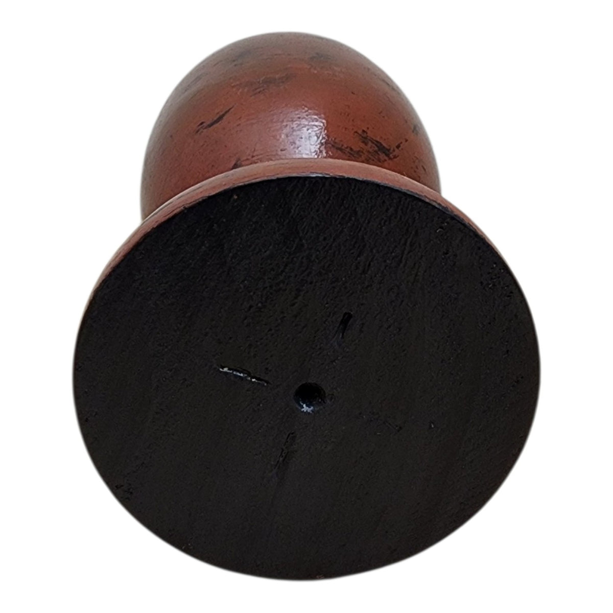 Base of solid wood decorative vessel showing black underside